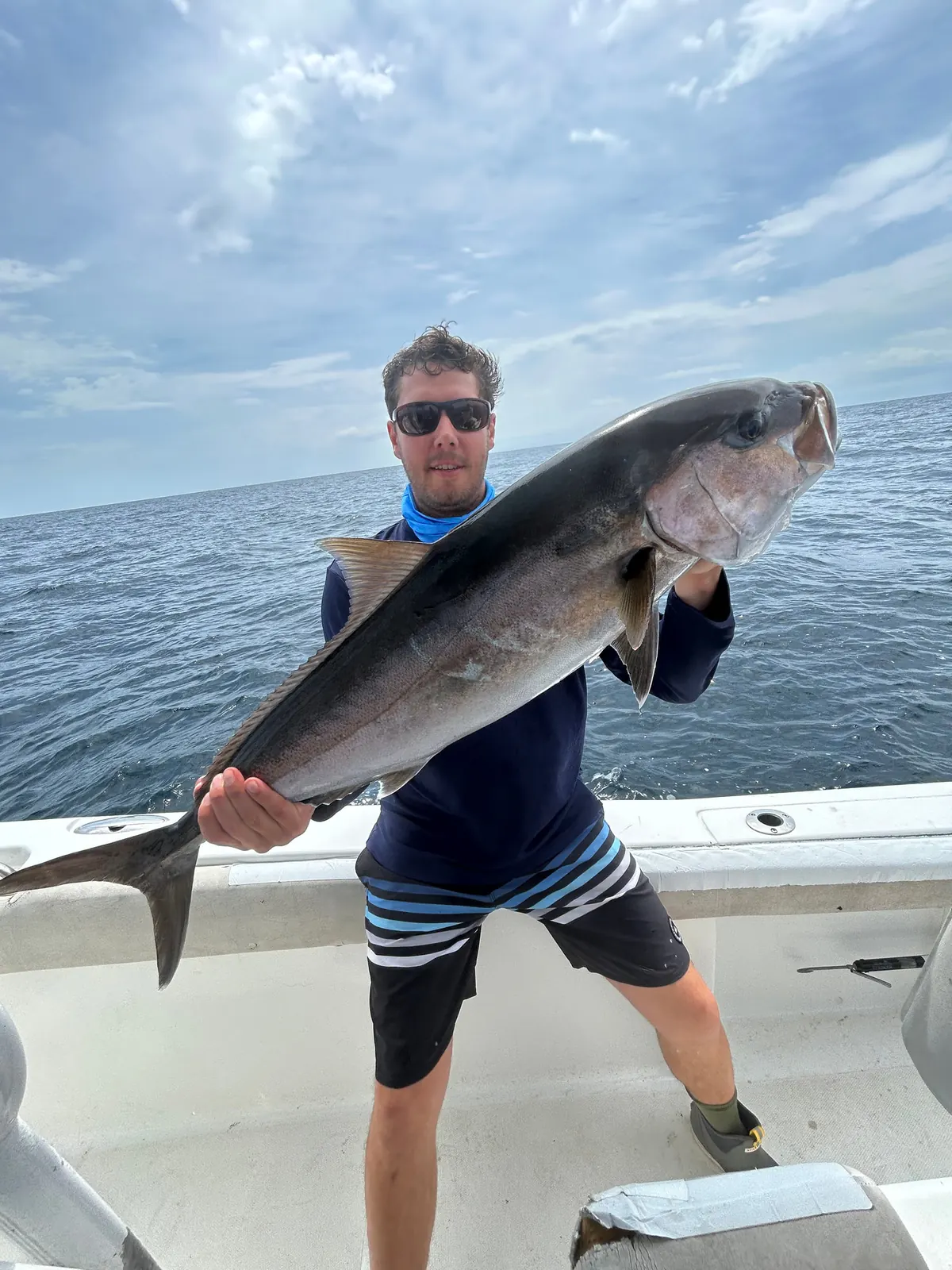 Tanner Bardin holding a large fish on the boat